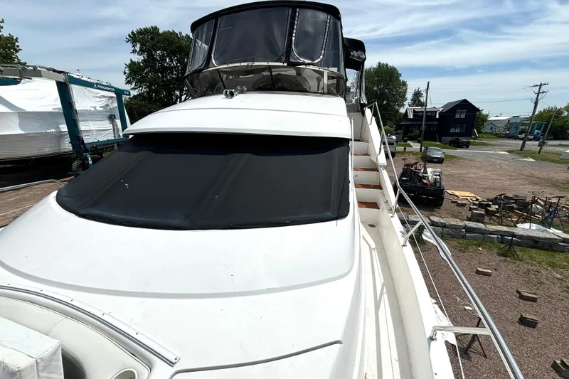 Slide: The Image of 1999 Silverton 453 Motor Yacht docked, showcasing sleek design and spacious deck. - 34