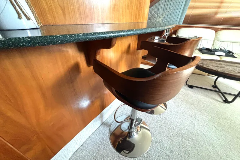 Slide: The Image of Interior of 1999 Silverton 453 Motor Yacht with wooden bar stools and elegant decor. - 41