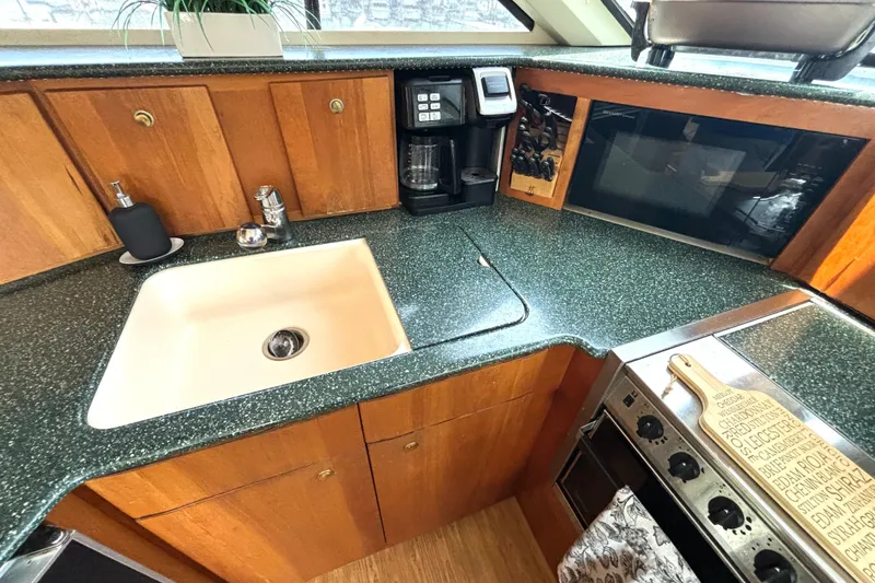 Slide: The Image of 1999 Silverton 453 Motor Yacht kitchen with sink, stove, and microwave. - 45