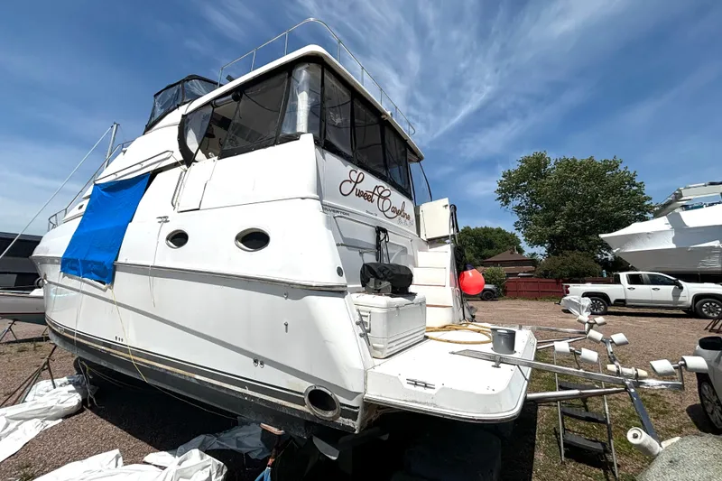 Slide: The Image of 1999 Silverton 453 Motor Yacht on land, with blue tarp and clear sky background. - 5
