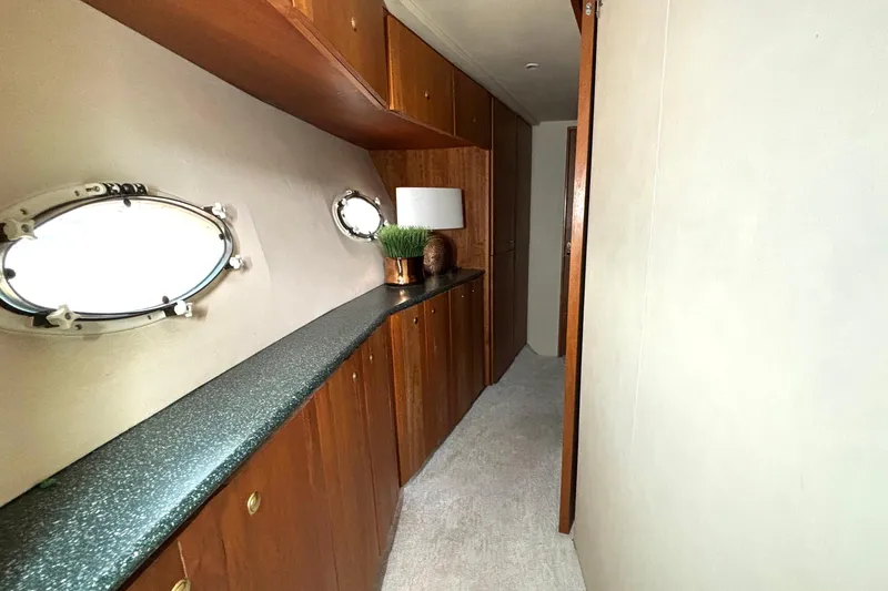 Slide: The Image of 1999 Silverton 453 Motor Yacht interior hallway with wooden cabinets and porthole windows. - 52