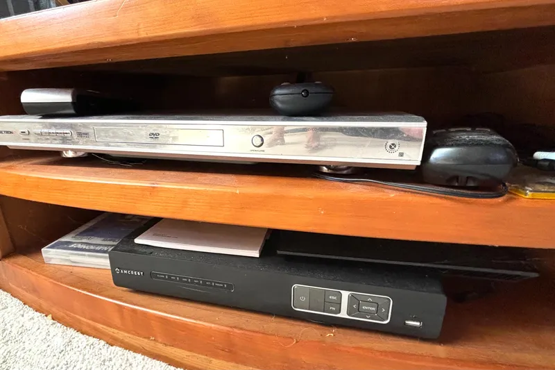 Slide: The Image of DVD player and electronic device on wooden shelf in a 1999 Silverton 453 Motor Yacht. - 60