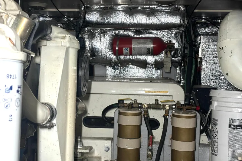 Slide: The Image of Engine room of a 1999 Silverton 453 Motor Yacht with fire extinguisher and fuel filters. - 68