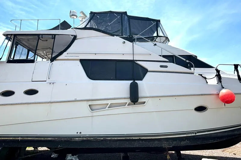Slide: The Image of 1999 Silverton 453 Motor Yacht with white exterior, docked under clear blue sky. - 74