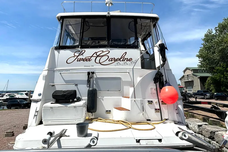 Slide: The Image of 1999 Silverton 453 Motor Yacht "Sweet Caroline" docked, featuring rear view with equipment and buoy. - 76