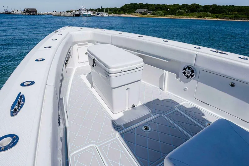 Slide: The Image of 2019 Concept 392 ProFish boat interior with seating and storage, docked near a scenic shoreline. - 22