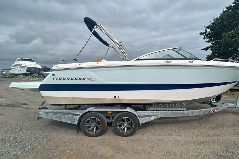 The Image of 2021 Chaparral 247 SSX boat on trailer, parked outdoors under cloudy sky. - 1