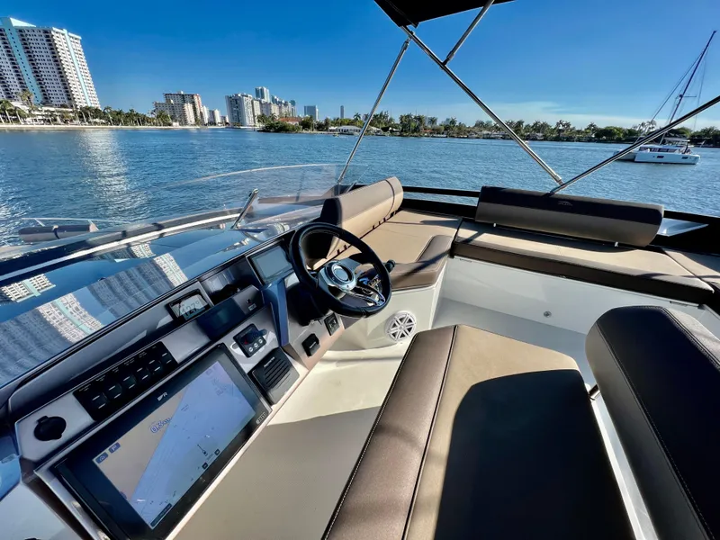 Slide: The Image of 2022 Galeon 470 Sky yacht helm with city skyline and water view. - 10