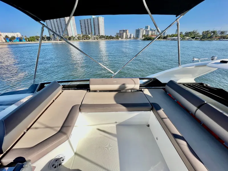 Slide: The Image of 2022 Galeon 470 Sky yacht with spacious seating area, overlooking a city skyline and calm waters. - 13