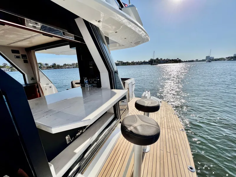 Slide: The Image of 2022 Galeon 470 Sky yacht with outdoor bar and stools on a sunny day. - 17