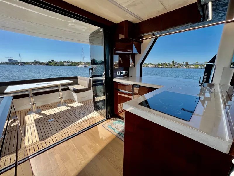 Slide: The Image of Interior view of 2022 Galeon 470 Sky yacht with modern kitchen and scenic water backdrop. - 20