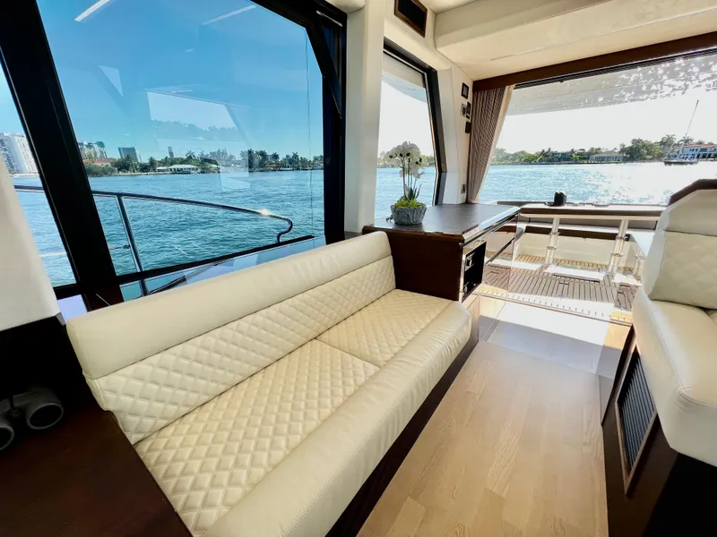 Slide: The Image of Interior of 2022 Galeon 470 Sky yacht with white leather seating and scenic water view. - 22