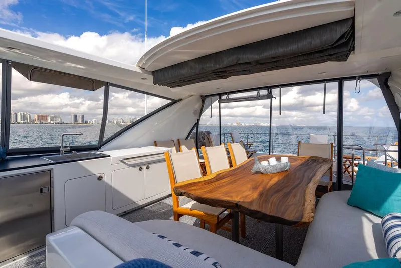 Slide: The Image of Luxurious yacht interior with wooden table, ocean view, and city skyline in the background. - 52