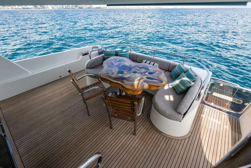 Slide: The Image of Luxurious yacht deck with custom wood table, cushioned seating, and ocean view. - 58
