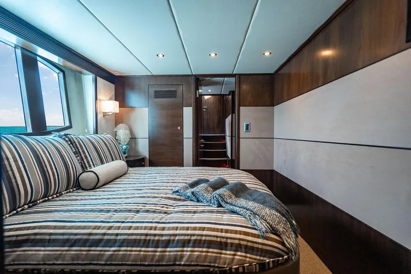 Slide: The Image of Luxurious yacht bedroom with striped bedding, modern wood paneling, and ocean view. Custom 73 Lanzarote, 2013. - 95
