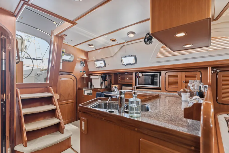 Slide: The Image of Luxurious 2009 Pasport 51 yacht interior with wooden cabinetry and modern kitchen amenities. - 14