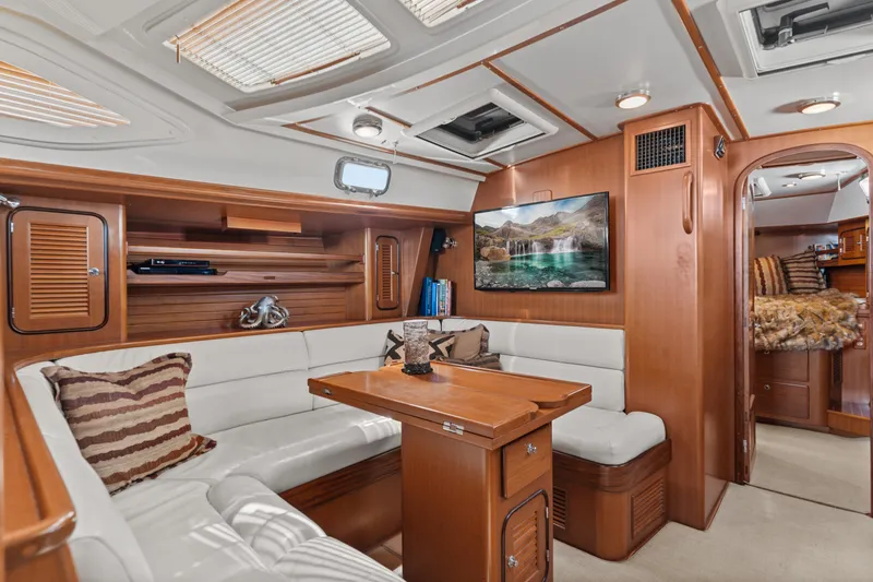 Slide: The Image of Luxurious 2009 Pasport 51 yacht interior with cozy seating, wooden finishes, and mounted TV. - 17