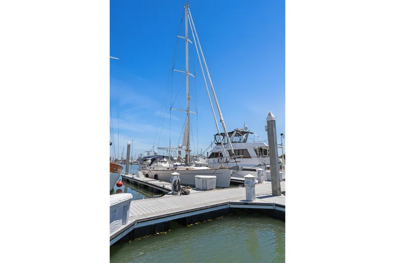 Slide: The Image of Sailboats docked at a marina under a clear blue sky, featuring a 2009 Pasport 51. - 3