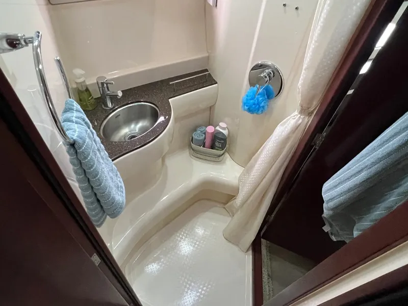 Slide: The Image of The image shows a boat bathroom with a sink, shower, and towels. - 26