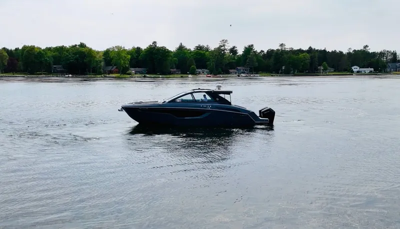 Slide: The Image of 2023 Cruisers Yachts 42 GLS on calm water near wooded shoreline. - 15