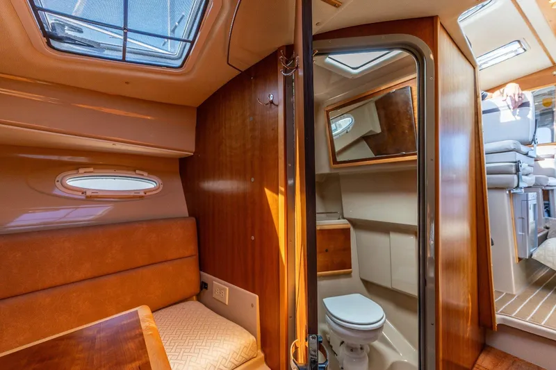 Slide: The Image of Interior of a 2015 Cutwater 28 boat featuring a cozy cabin and compact bathroom. - 12