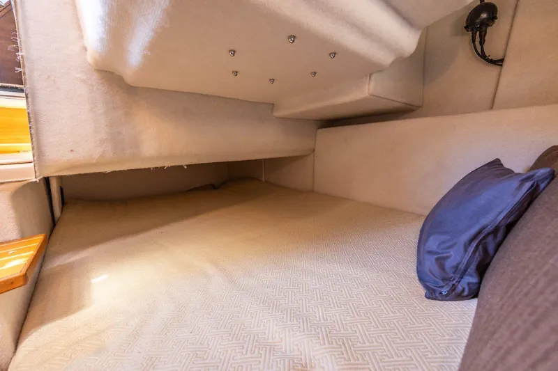 Slide: The Image of Interior cabin of a 2015 Cutwater 28 boat, featuring a cozy sleeping area. - 13