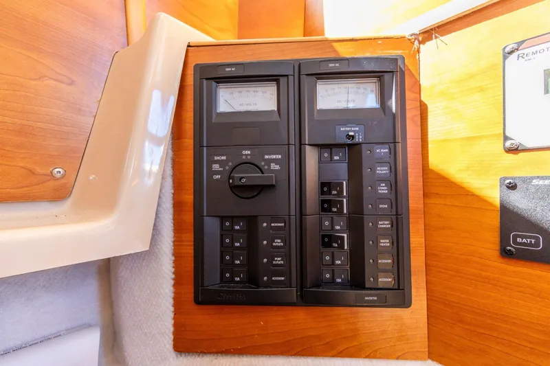 Slide: The Image of Electrical panel on a 2015 Cutwater 28 boat, featuring switches and meters. - 17