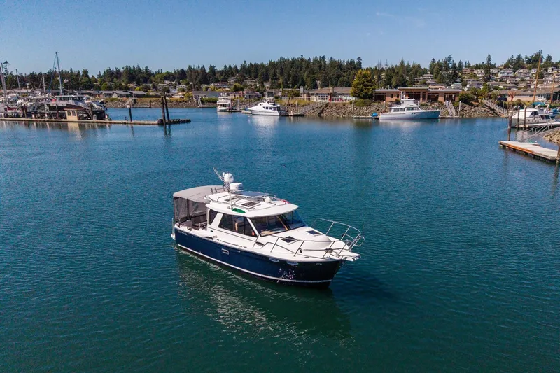 Slide: The Image of 2015 Cutwater 28 boat cruising in a scenic marina with clear blue water. - 2