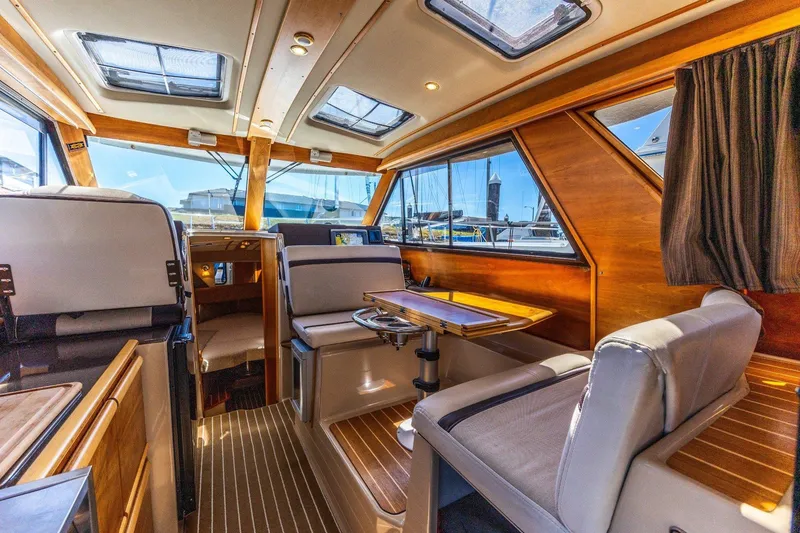Slide: The Image of Interior of a 2015 Cutwater 28 boat, featuring wood accents and seating area. - 5