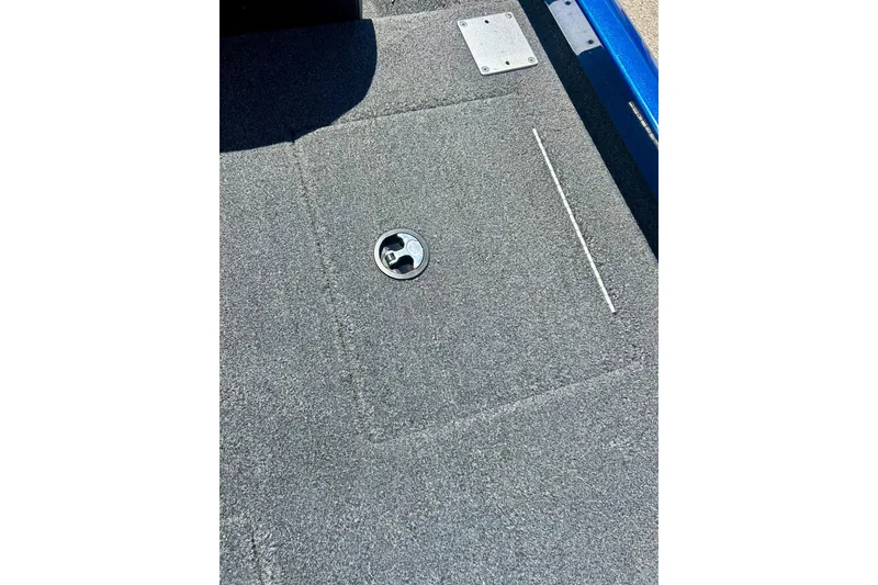 Slide: The Image of Carpeted deck of a 2017 Triton 18 C TX boat with a hatch and metal fittings. - 27