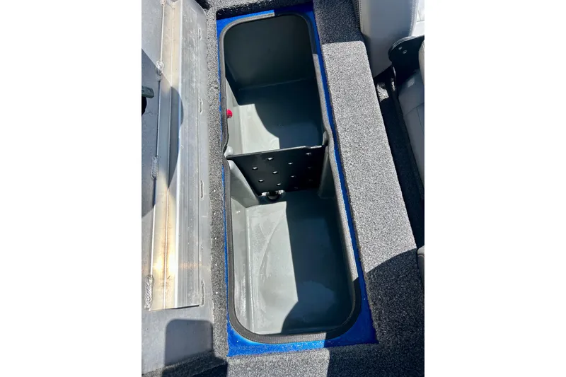 Slide: The Image of Open storage compartment in 2017 Triton 18 C TX boat, featuring gray interior and carpeted edges. - 30