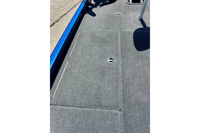 Slide: The Image of 2017 Triton 18 C TX boat deck with gray carpet and storage hatch. - 31