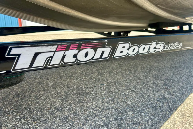 Slide: The Image of Triton 18 C TX 2017 boat trailer with logo on pavement background. - 44
