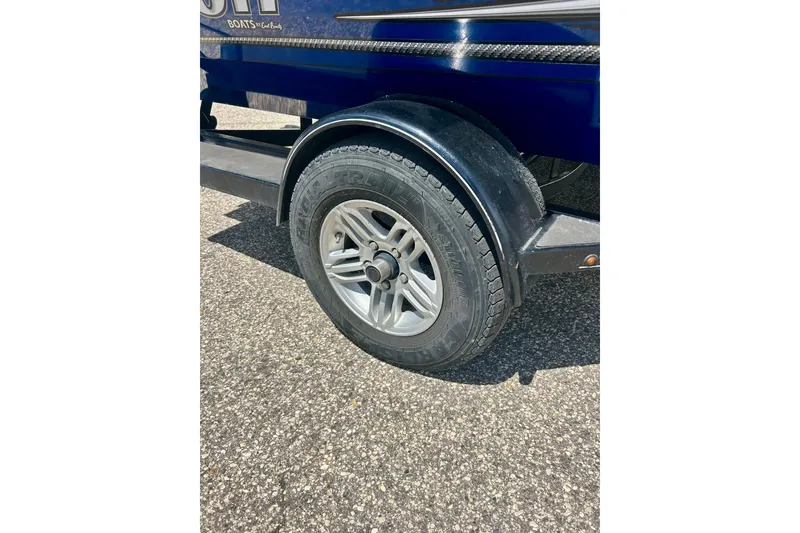 Slide: The Image of 2017 Triton 18 C TX boat trailer wheel on asphalt surface. - 46
