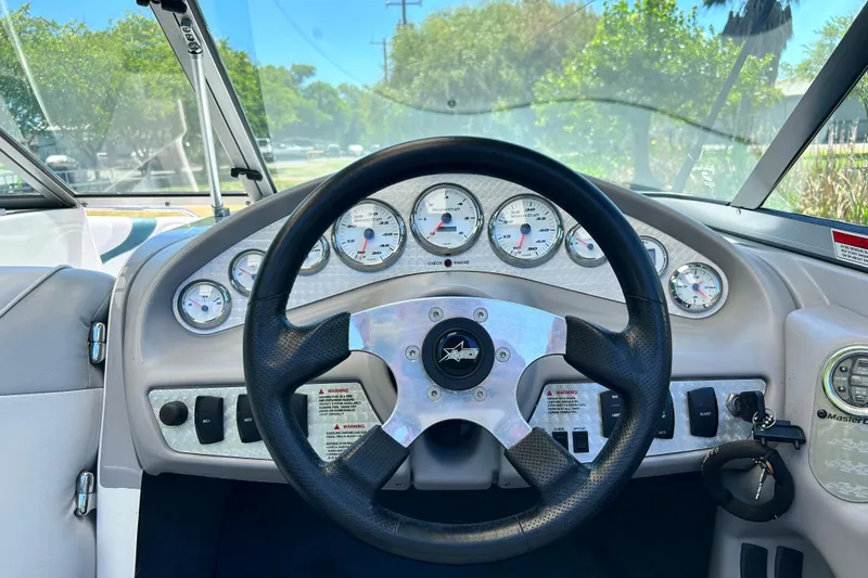 Slide: The Image of Steering wheel and dashboard of a 2002 MasterCraft ProStar 197 boat, featuring multiple gauges. - 12