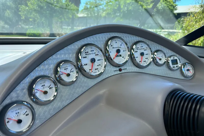 Slide: The Image of Dashboard of a 2002 MasterCraft ProStar 197 boat with multiple gauges and dials. - 13