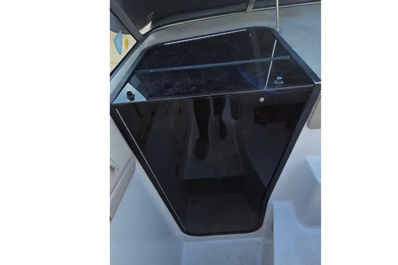Slide: The Image of 1999 Four Winns 258 Vista boat cabin entrance with black door and sleek design. - 11
