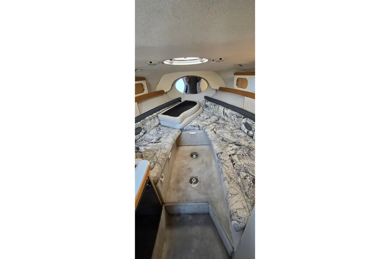 Slide: The Image of 1999 Four Winns 258 Vista cabin interior with patterned seating and overhead lighting. - 14