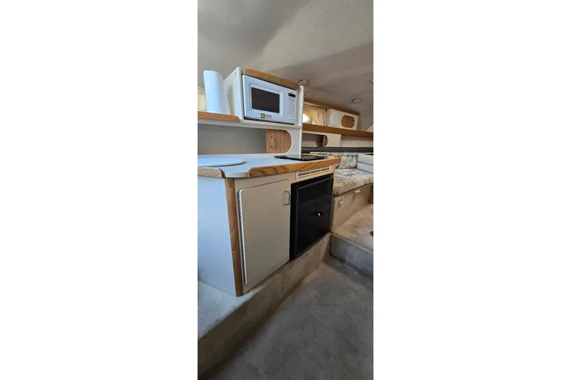 Slide: The Image of Interior of 1999 Four Winns 258 Vista boat with kitchenette and seating area. - 15