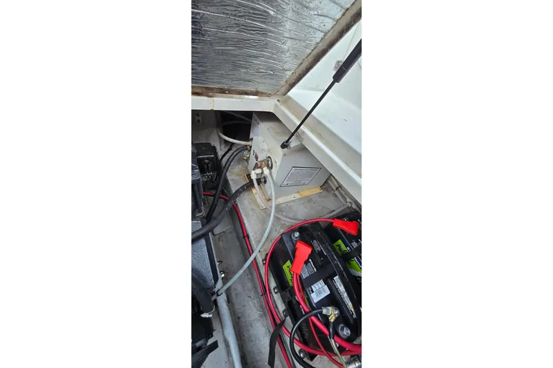 Slide: The Image of Engine compartment of a 1999 Four Winns 258 Vista boat, showing battery and wiring. - 23