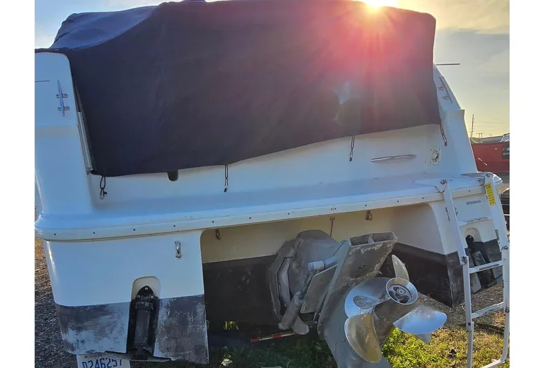 Slide: The Image of 1999 Four Winns 258 Vista boat rear view with covered deck and visible propeller. - 4