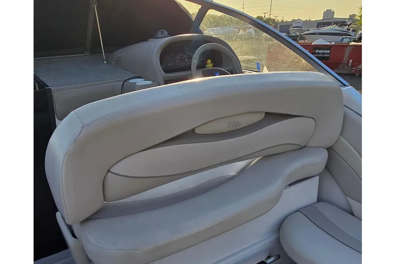 Slide: The Image of 1999 Four Winns 258 Vista boat interior with beige seating and dashboard view. - 7