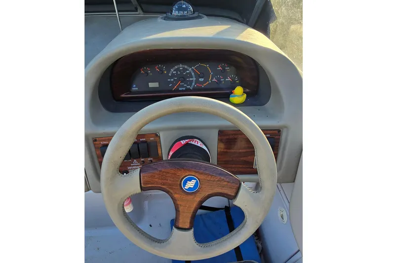 Slide: The Image of Steering wheel and dashboard of a 1999 Four Winns 258 Vista boat. - 8