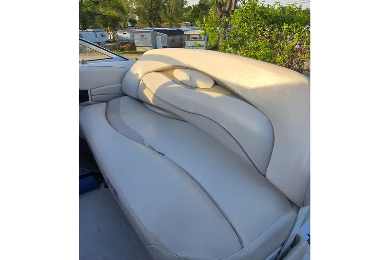 Slide: The Image of 1999 Four Winns 258 Vista boat interior with beige seating and outdoor view. - 9