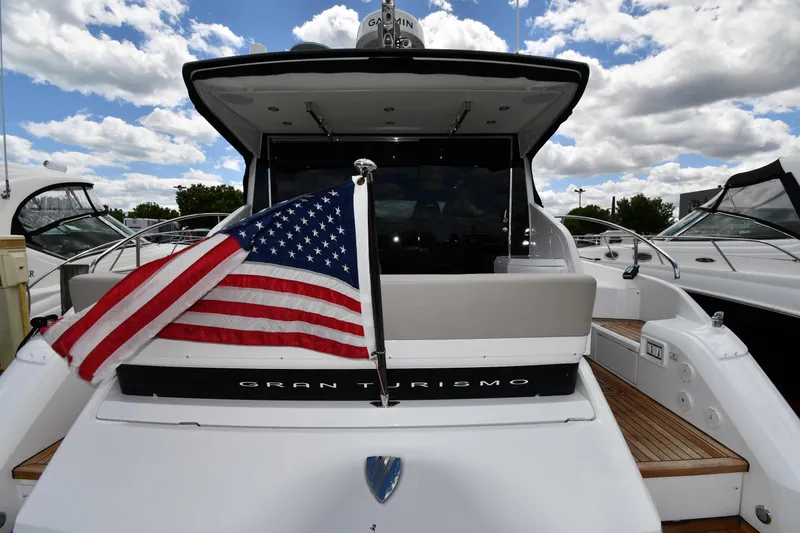 Slide: The Image of 2024 Fairline G50 Targa yacht with American flag, docked under a cloudy sky. - 11