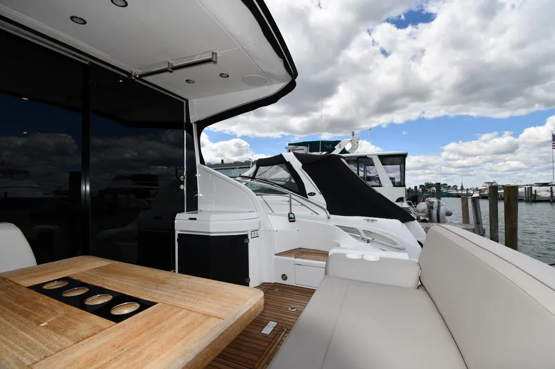 Slide: The Image of 2024 Fairline G50 Targa yacht deck with seating and table, docked at marina. - 12