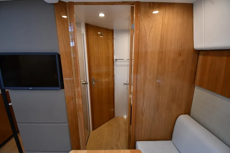 Slide: The Image of Interior of 2024 Fairline G50 Targa yacht with wooden finishes and a mounted TV. - 29