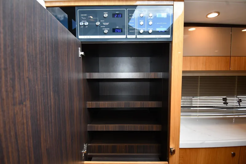 Slide: The Image of 2024 Fairline G50 Targa yacht interior with open wooden cabinet and control panel. - 35