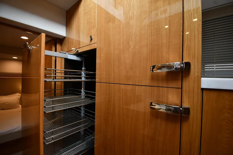 Slide: The Image of Interior of 2024 Fairline G50 Targa yacht with wooden cabinetry and pull-out storage. - 36
