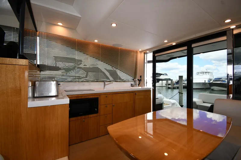 Slide: The Image of Luxurious interior of 2024 Fairline G50 Targa yacht with modern kitchen and marina view. - 48
